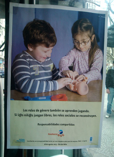 Um menino e uma menina brincam de trocar as fraldas de um boneco Um menino e uma menina brincam de trocar as fraldas de um boneco